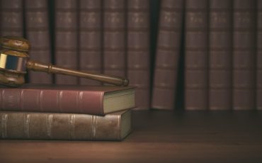Gavel on the background of vintage lawyer books. Concept of law and justice. 3d illustration